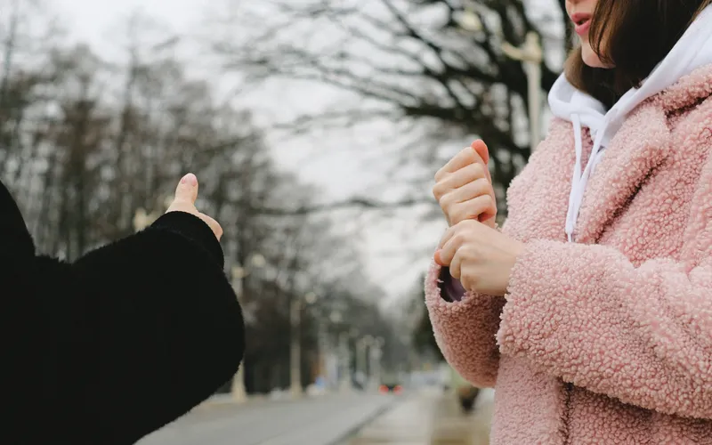 Two people having a conversation in sign language outdoors